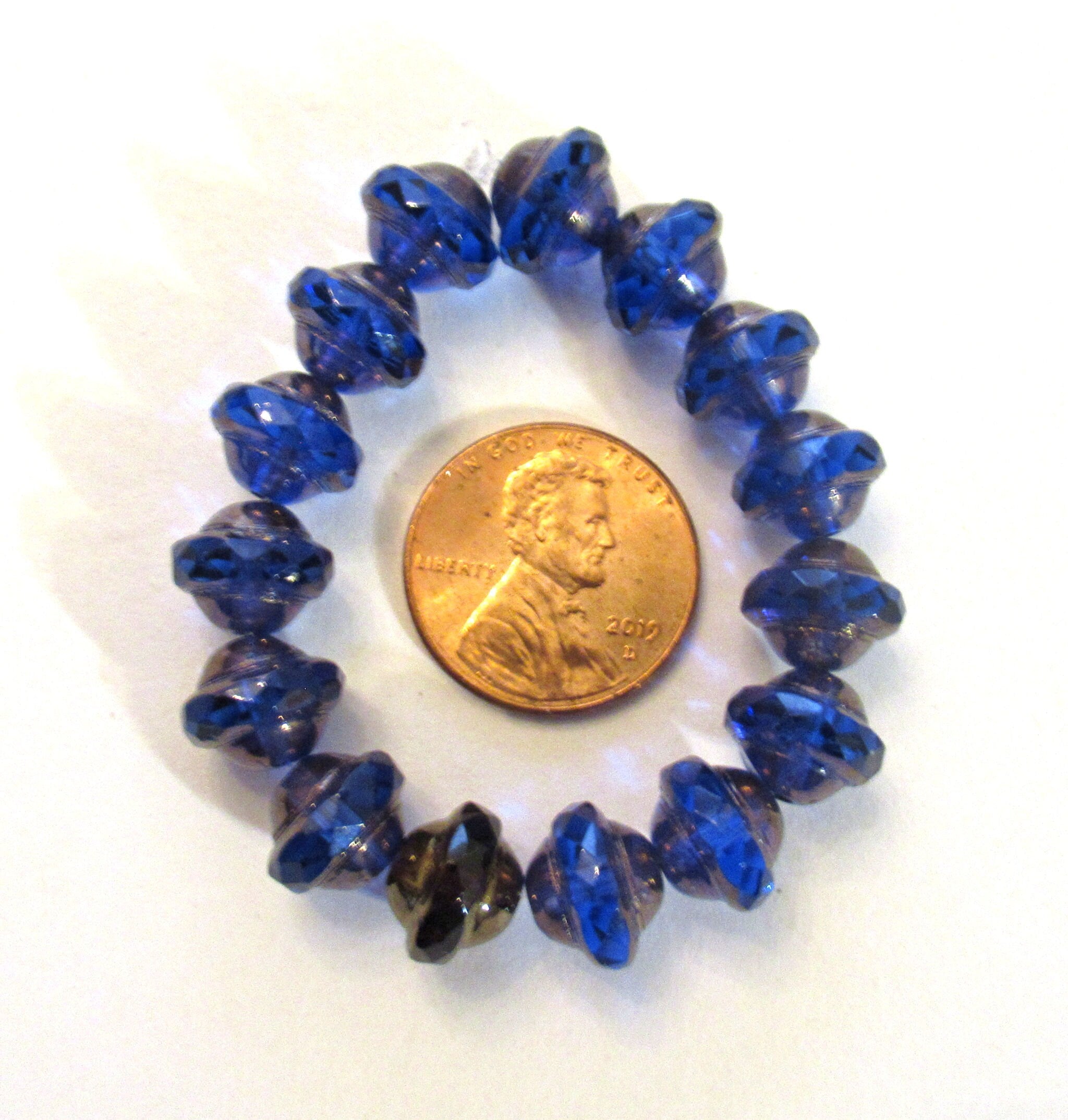 Fifteen Czech glass saturn beads - 8mm x 10mm transparent sapphire blue faceted fire polished saucer beads with a bronze finish - C00971