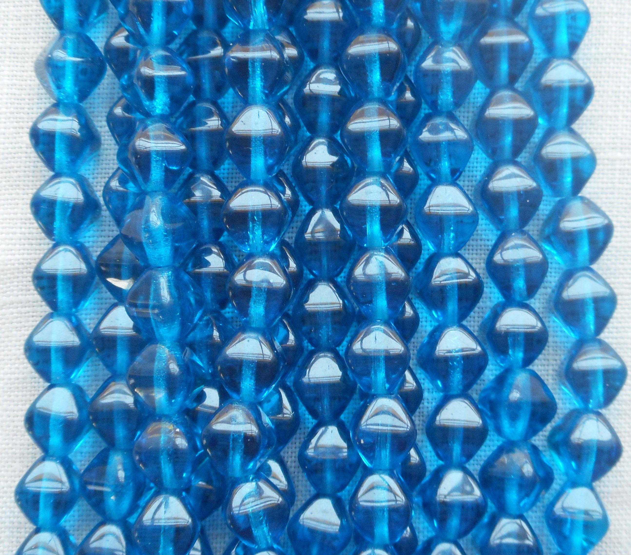 Fifty 6mm Capri Blue bicones, pressed glass Czech beads, C8550