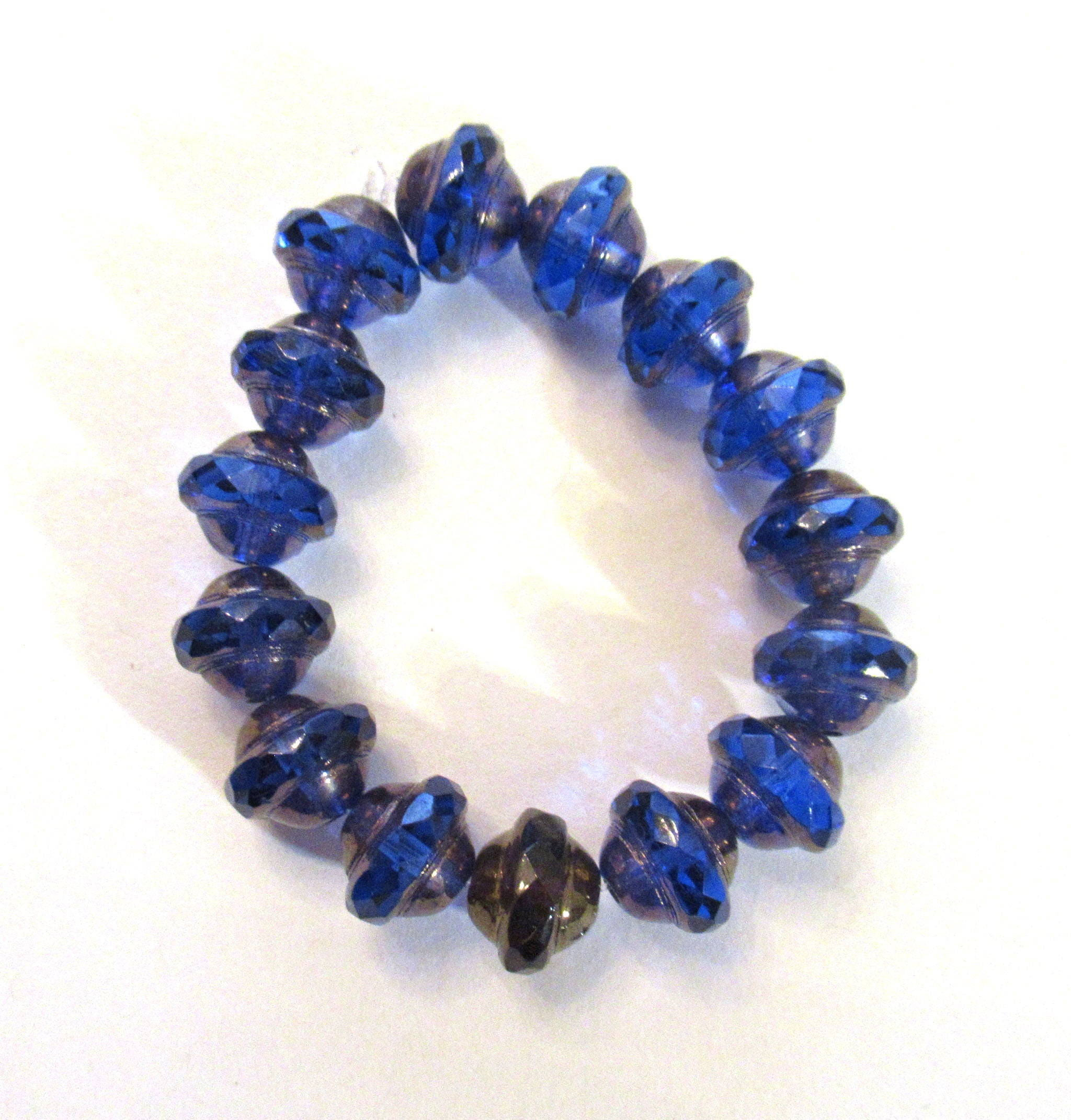 Fifteen Czech glass saturn beads - 8mm x 10mm transparent sapphire blue faceted fire polished saucer beads with a bronze finish - C00971