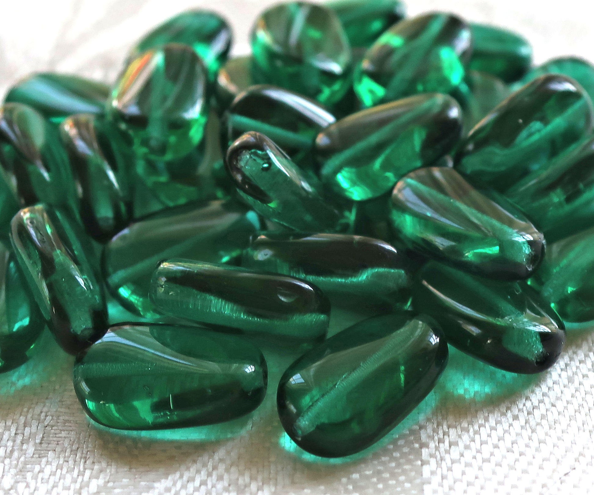 Lot of 25 transparent Teal Green slightly twisted oval Czech Glass beads, 14mm x 8mm pressed glass beads C7325 - Glorious Glass Beads