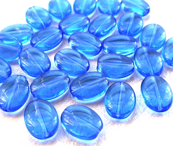 Lot of 25 transparent sapphire blue flat oval Czech Glass beads, 12mm x 9mm pressed glass beads C7425 - Glorious Glass Beads