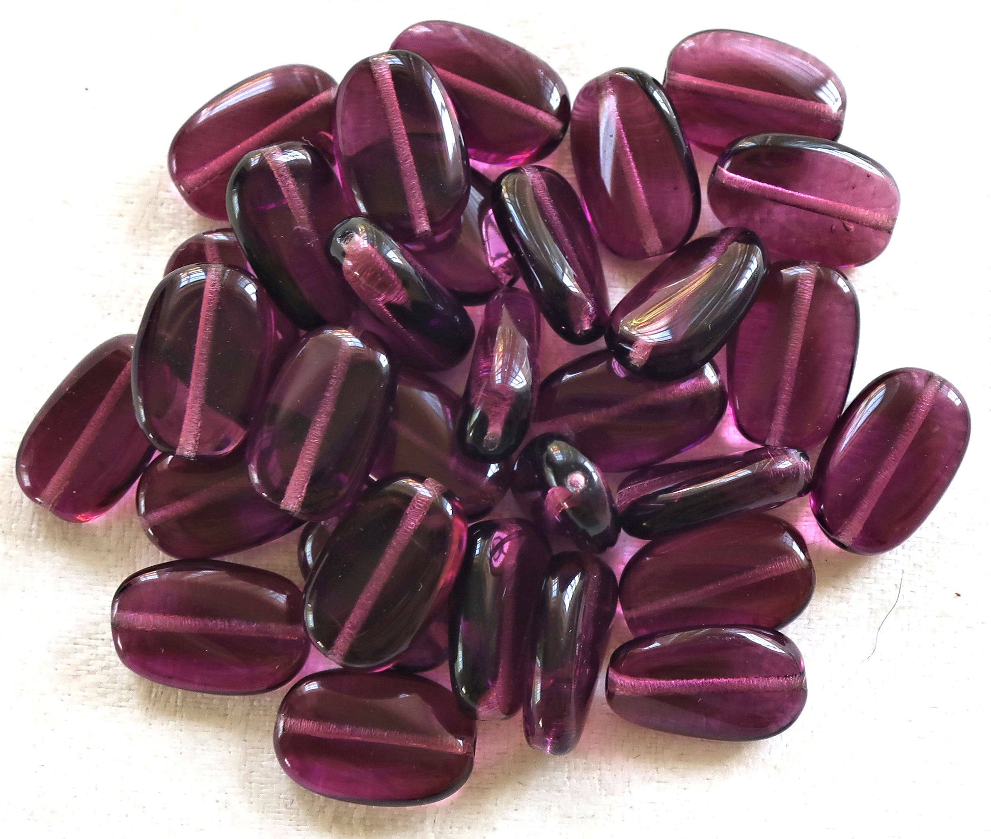 Lot of 25 transparent Amethyst, Purple slightly twisted oval Czech Glass beads, 14mm x 8mm pressed glass beads C2925 - Glorious Glass Beads