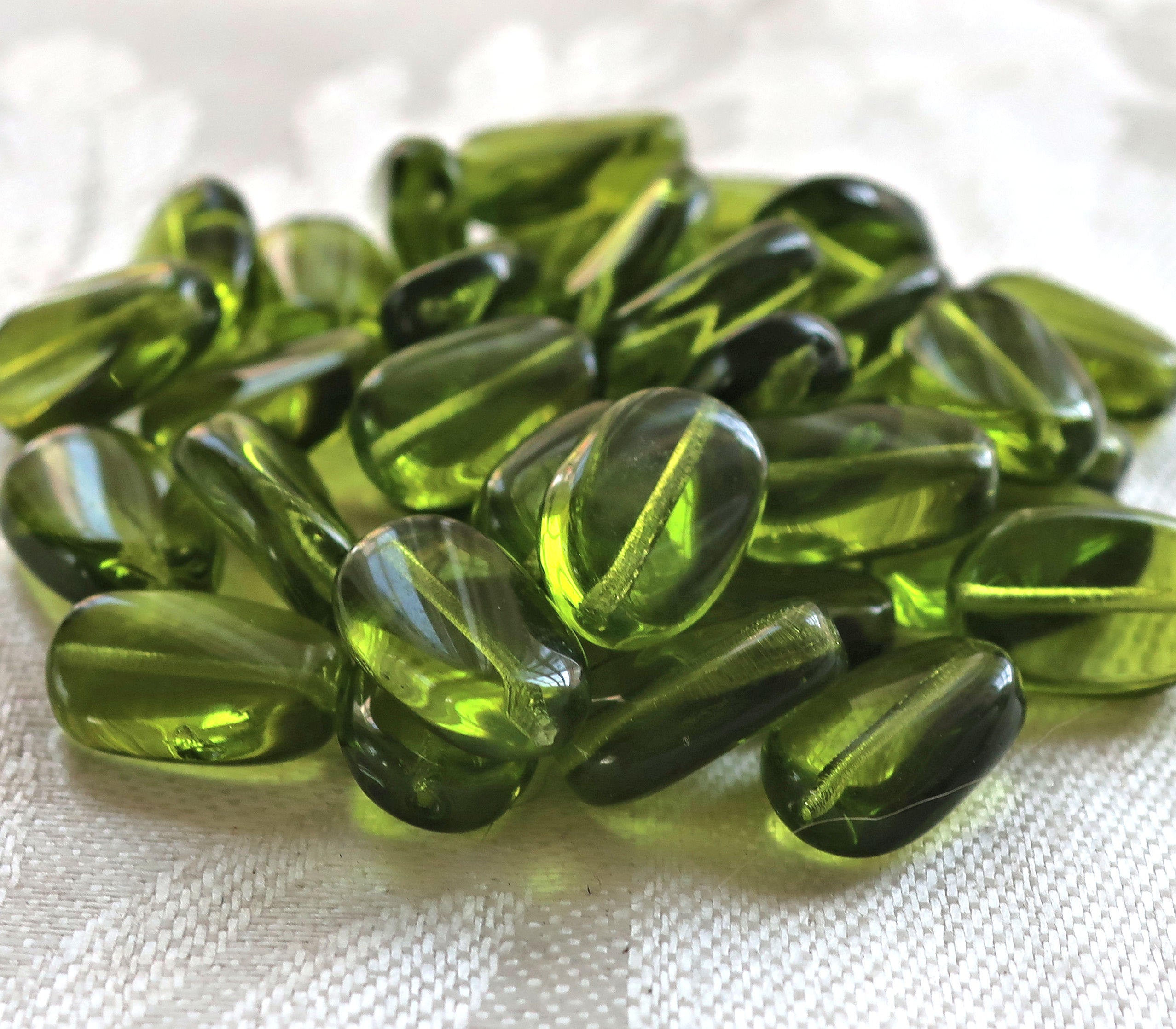 Lot of 25 transparent Olivine, Olive Green slightly twisted oval Czech Glass beads, 14mm x 8mm pressed glass beads C2925 - Glorious Glass Beads