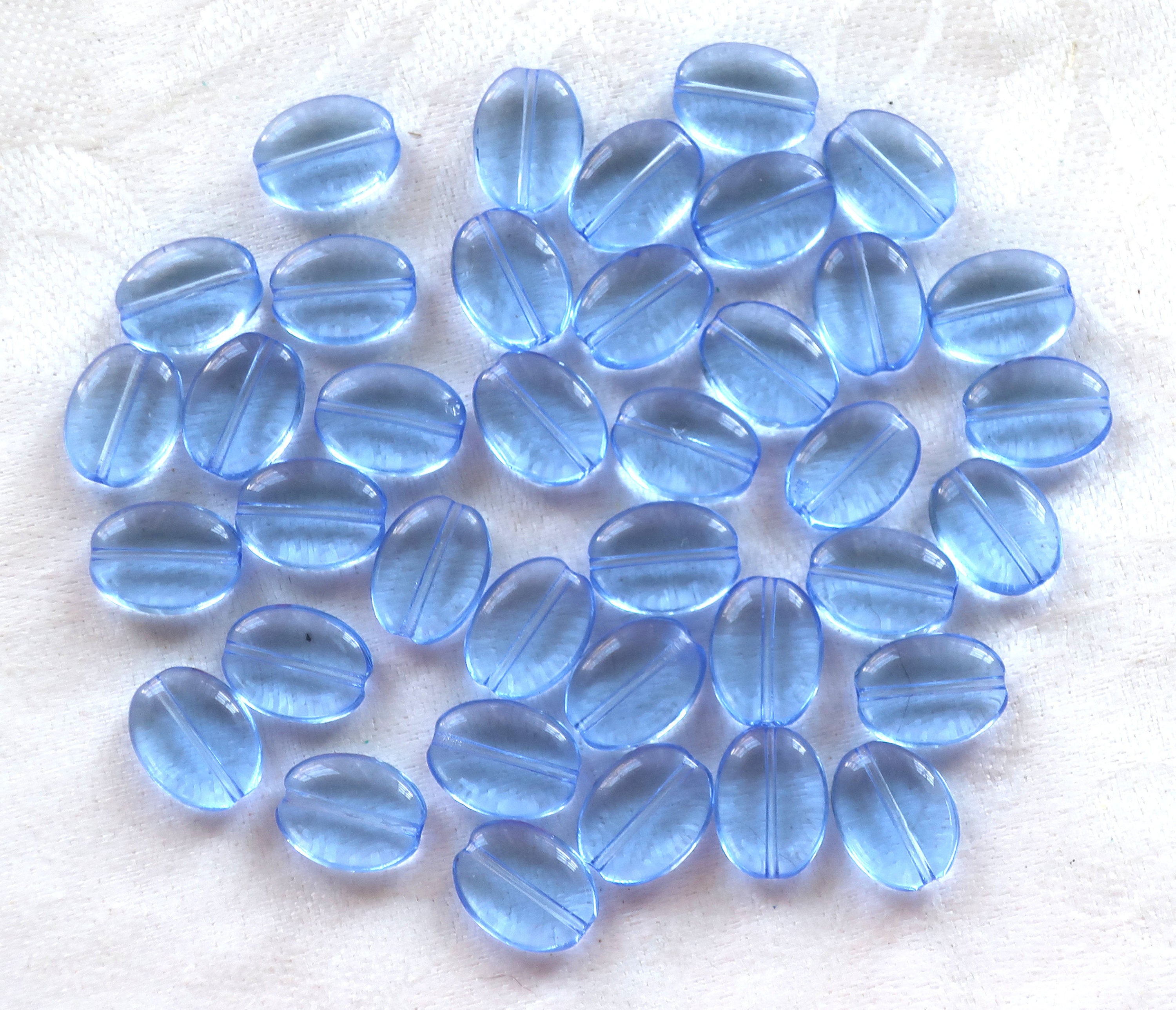 25 transparent light sapphire blue flat oval Czech Glass beads, 12mm x 9mm pressed glass beads C6425 - Glorious Glass Beads