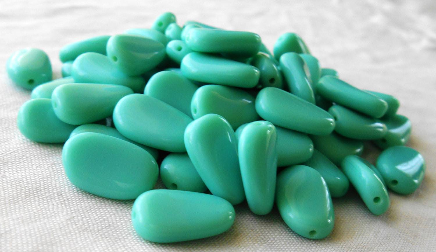 Lot of 25 Opaque Turquoise slightly twisted oval Czech pressed Glass beads, 14mm x 8mm, 03125 - Glorious Glass Beads