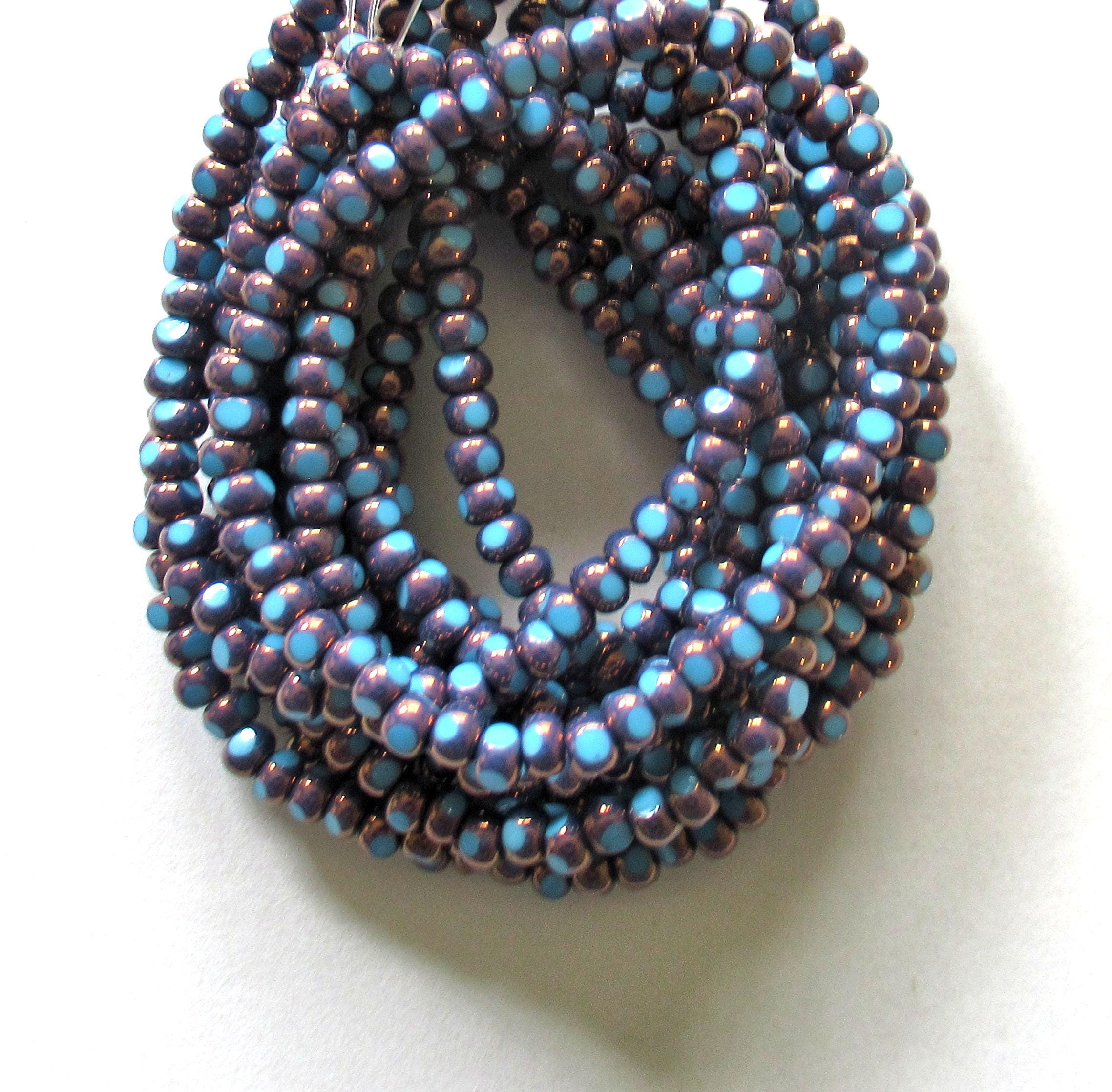 Fifty 6/0 tri cut faceted Czech glass seed beads - opaque light turquoise blue w/ purple bronze accents - C00331
