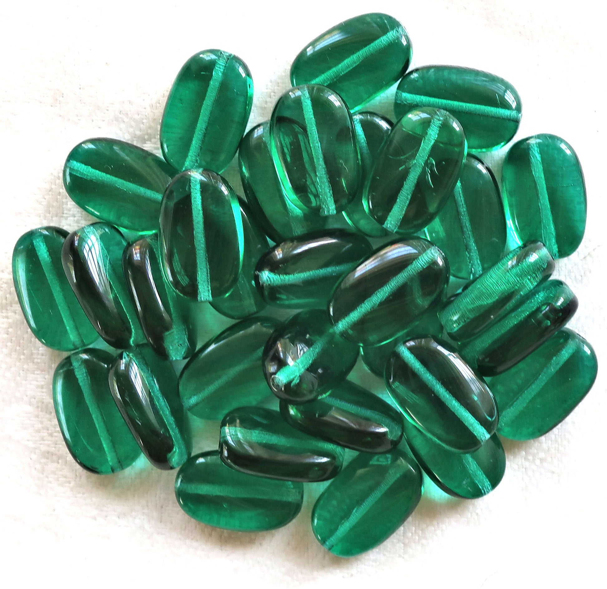 Lot of 25 transparent Teal Green slightly twisted oval Czech Glass beads, 14mm x 8mm pressed glass beads C7325 - Glorious Glass Beads